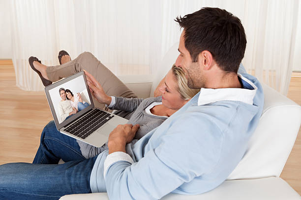 Loving couple having online video conference at home