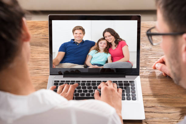 Close-up Of Couple Videoconferencing With Family On Laptop